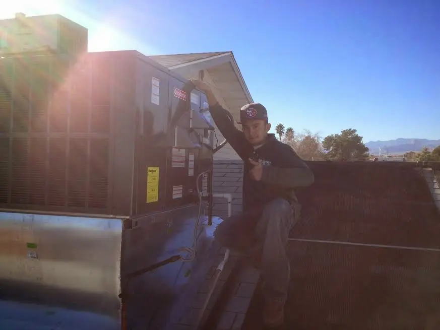 HVAC technician performing Air Duct Cleaning on a rooftop unit in Edmonds